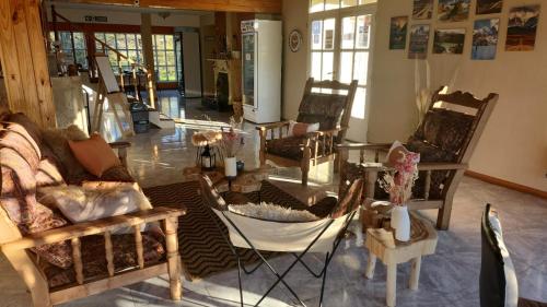 a living room filled with chairs and a table at Hotel Lago del Desierto in El Chalten