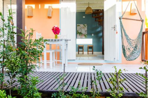 a front porch with a table and chairs at Vila Charme in Jericoacoara