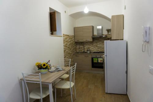 a kitchen with a table with chairs and a refrigerator at Tenute Valerio 