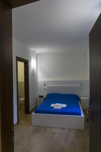 a bedroom with a blue bed and a bathroom at Tenute Valerio in Campana