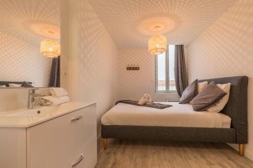 une petite chambre avec un lit et un lavabo dans l'établissement ATYPIQUE - 2 chambres avec salles de bains, cuisine équipée, parking gratuit, à Castelsarrasin