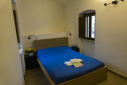 Un dormitorio con una cama azul con toallas. en Tenute Valerio 