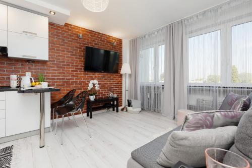 a living room with a brick wall at Bright & Cozy Studio near Metro Marymont by Renters in Warsaw