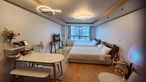 Schlafzimmer mit einem Bett, einem Tisch und einem Schreibtisch in der Unterkunft Posh_HongDae in Seoul