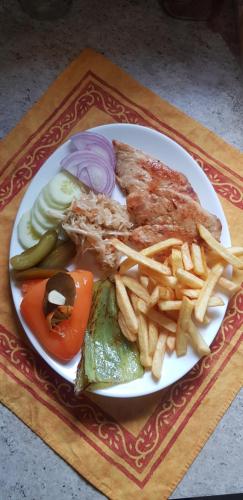 a plate of food with french fries and meat at PROKLETIJE eko katun Vusanje in Gusinje