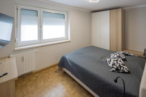 a bedroom with a bed and two windows at Top 4 in Bruck an der Mur