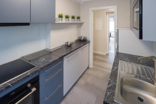 a kitchen with blue cabinets and a sink at Top 4 in Bruck an der Mur