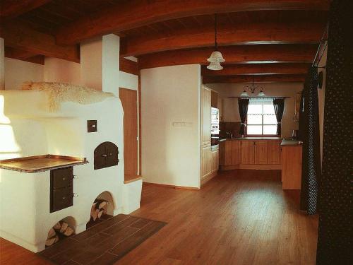 a kitchen with a fireplace in the middle of a room at Valachy chalupa Velké Karlovice in Velké Karlovice