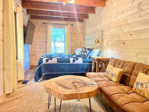 uma sala de estar com um sofá e uma cama em Modern lake side nest• HOTUB Fenced YARD king beds em Sevierville