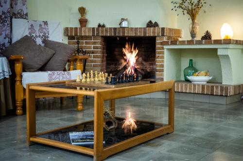 una sala de estar con un tablero de ajedrez frente a una chimenea en Hostal Montserrat, en Montseny