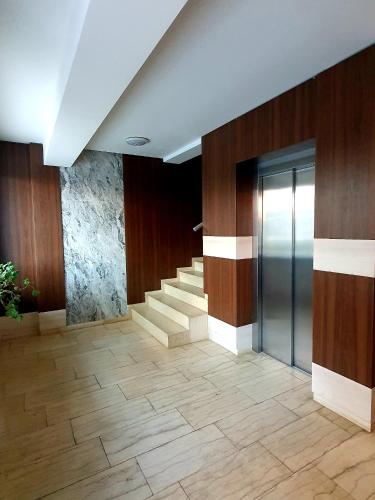 a lobby with stairs and a glass elevator at 'Just like home' Apartment - with Private Parking Place in Galaţi