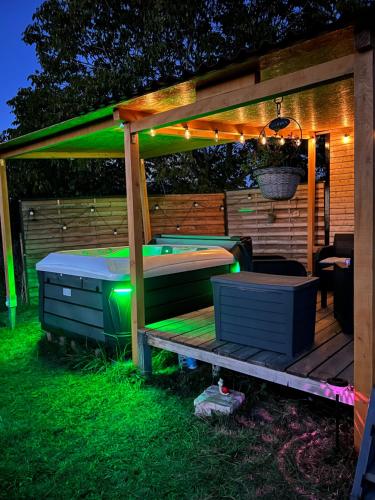 a pergola with a bed and a table with lights at Roulotte „douceur“ in Condom