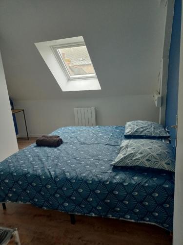 una camera da letto con un letto con un piumone blu di appart 2 chambres a Noyen-sur-Sarthe