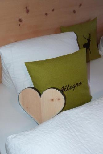 a bed with a pillow with a heart on it at Wellnesshotel Liun in Müstair
