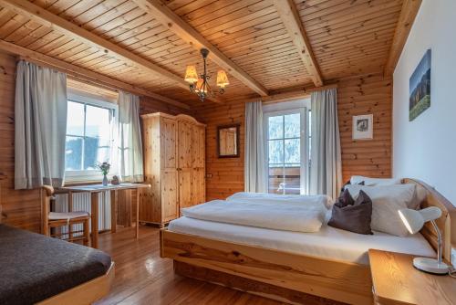 a bedroom with a large bed in a room with wooden walls at Apartmenthaus - Erlebenswert Bauernhof Gruber in Sankt Lorenzen im Lesachtal