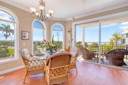 a dining room with a table and chairs and windows at Villa Vista Mare - 675 in Siesta Key