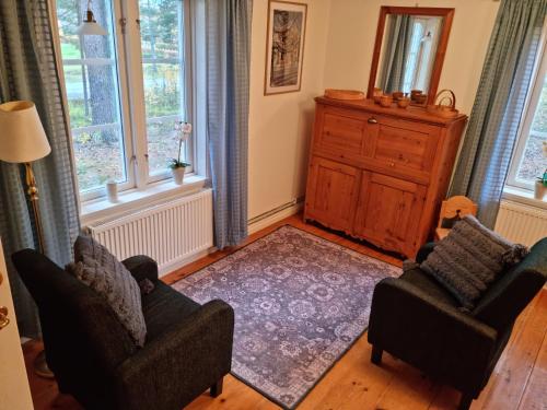ein Wohnzimmer mit 2 Stühlen und einer Kommode in der Unterkunft Midgård in Jörn
