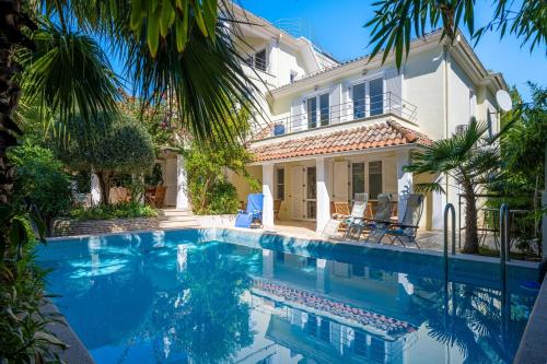 a villa with a swimming pool in front of a house at Villa Gardenia in Premantura