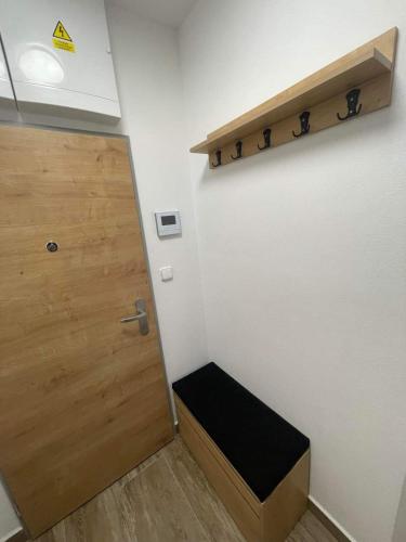 a room with a door and a bench next to a wall at Apartmán v Kašperských Horách in Kašperské Hory