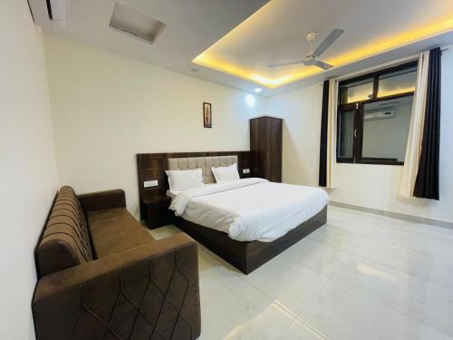 1 dormitorio con 1 cama y 1 sofá en Divine Ganga by MJ Hospitality, en Haridwar