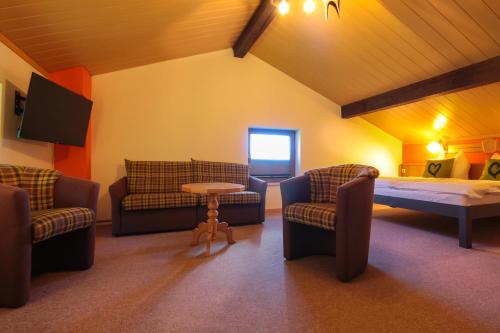 a living room with couches and a bed and a table at Haus am Berg - Pension direkt am Skihang in Kurort Oberwiesenthal