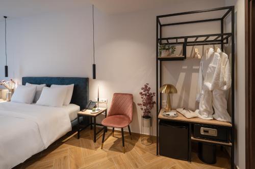 een slaapkamer met een bed en een bureau met een stoel bij IRA - ΗΡΑ City Hotel in Kalamata