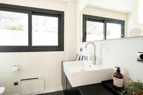 łazienka z umywalką i 2 oknami w obiekcie Hill house Spain -villa casa blanca w Almuñécar