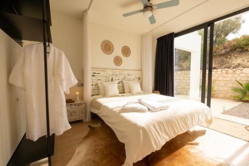sypialnia z łóżkiem z białą pościelą i wentylatorem w obiekcie Hill house Spain -villa casa blanca w Almuñécar