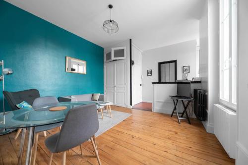 a living room with a table and a blue wall at Le Clem - Appartement centre ville - Idéal Cure et Parcs in Vichy