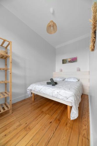 Ce lit se trouve dans un dortoir doté de parquet. dans l'établissement Le Clem - Appartement centre ville - Idéal Cure et Parcs, à Vichy