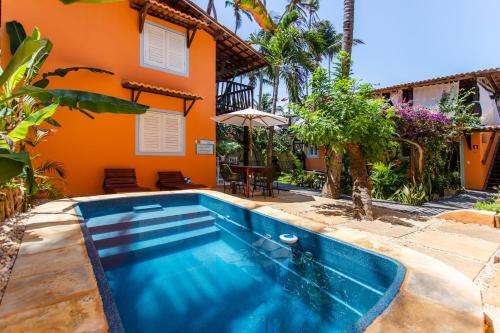 a swimming pool in front of a house at Vila Charme in Jericoacoara
