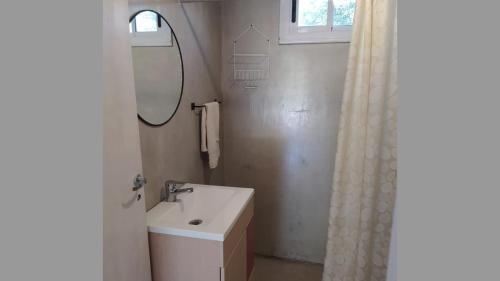 a white bathroom with a sink and a mirror at Casa de Montaña in Cortaderas