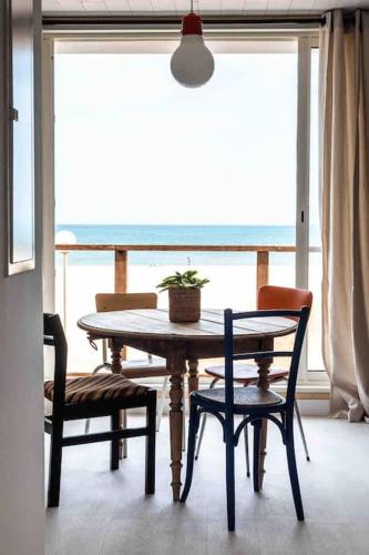 une table et des chaises dans une pièce avec une fenêtre dans l'établissement Le ciel, le soleil et la mer, à Narbonne