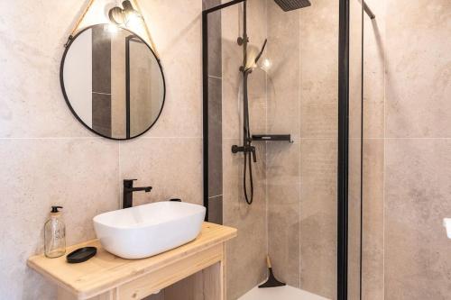 a bathroom with a sink and a shower with a mirror at Le ciel, le soleil et la mer in Narbonne