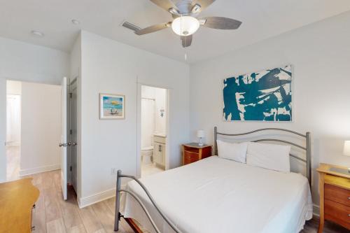 1 dormitorio con 1 cama y ventilador de techo en The Peach at the Beach, en Orange Beach