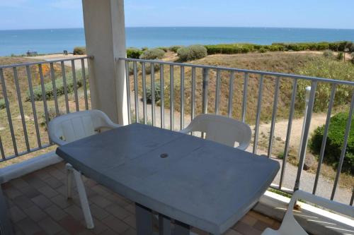 une table et des chaises sur un balcon avec l'océan dans l'établissement 060 Jardin de la Conque B13, au Cap d'Agde