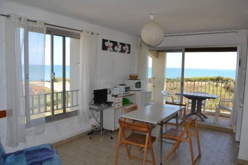 Il dispose d'un balcon et d'une cuisine avec une table et des chaises. dans l'établissement 060 Jardin de la Conque B13, au Cap d'Agde