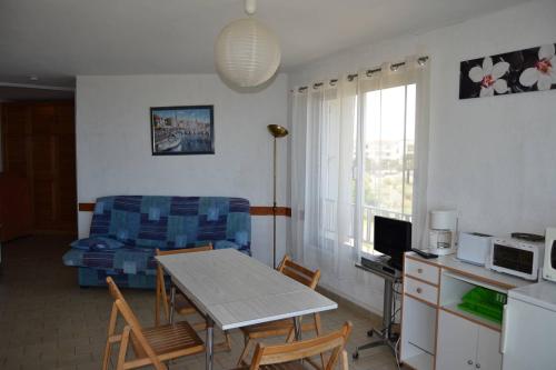 un salon avec une table et un canapé dans l'établissement 060 Jardin de la Conque B13, au Cap d'Agde