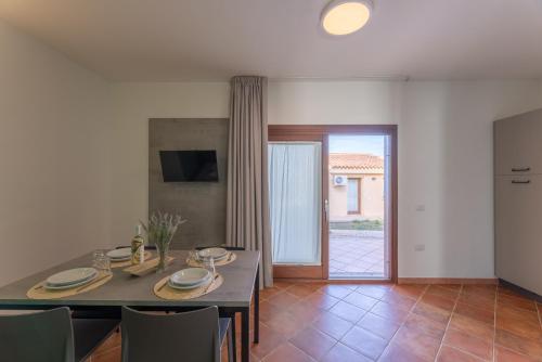 - une cuisine et une salle à manger avec une table et des chaises dans l'établissement Residence Le Rocce Rosse, à Isola Rossa
