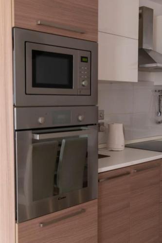 a kitchen with an oven with two chairs in it at Upper Valley Mansions, No.25 in Cospicua