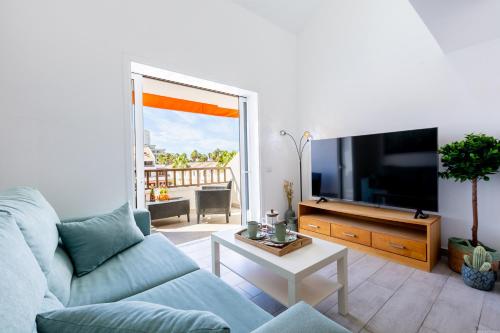 ein Wohnzimmer mit Couch und Flachbildfernseher in der Unterkunft Luxury Parque Santiago I in Playa de las Americas