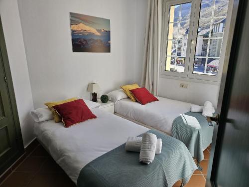 a room with two beds and two windows at IMEDA Apartamento Salvia Dos Dormitorios in Sierra Nevada