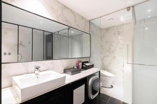 a bathroom with a sink and a washing machine at Cacao Hotel in Incheon