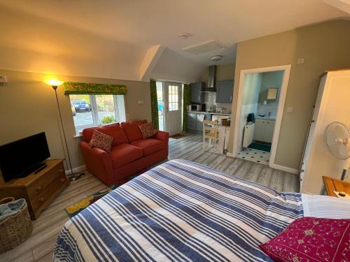 a bedroom with a bed and a living room at Pentre Cerrig Country House in Llanferres