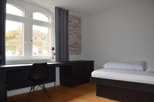 a bedroom with a bed and a desk and a window at Alter Bahnhof Ortenberg in Ortenberg