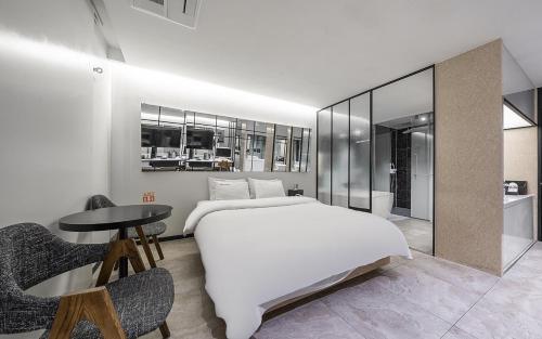 a bedroom with a large white bed and a table at Cacao Hotel in Incheon