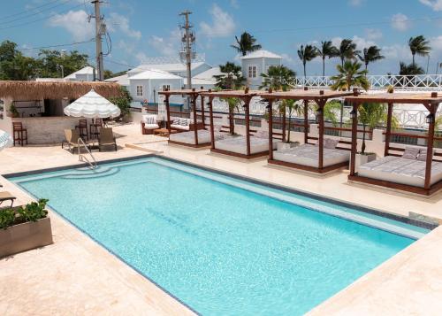 einen Pool mit Stühlen und einem Sonnenschirm in einem Resort in der Unterkunft Parguera Plaza Hotel - Adults Only in La Parguera