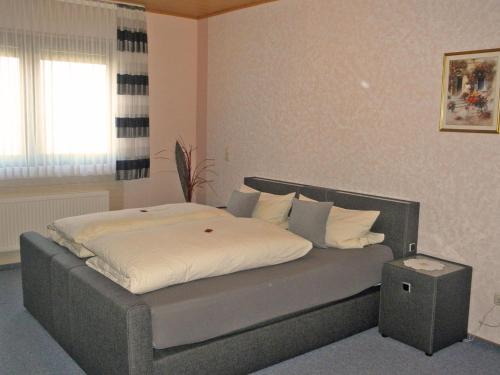 1 dormitorio con 1 cama grande con sábanas blancas en Ferienwohnung Martina, en Medebach