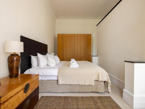 um quarto com uma cama grande e uma cabeceira em madeira em Pass the Keys Sophisticated Studio in South Kensington em Londres