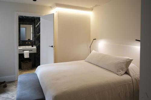 a bedroom with a white bed and a sink at Cool&Modern Apt para 4pax en el centro de Sevilla in Seville